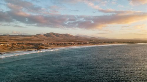 Free Breathtaking aerial view of the serene Spanish coastline and mountains at sunrise with a tranquil sea. Stock Photo