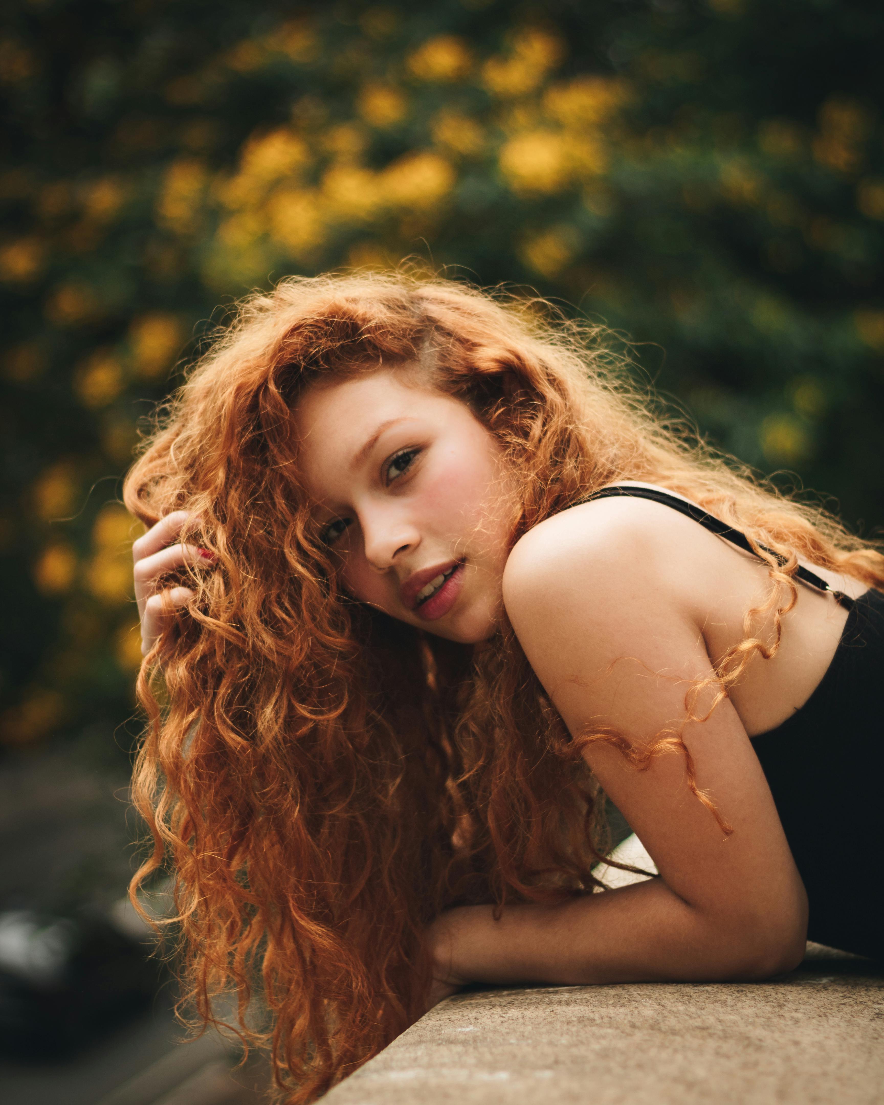 一位红发卷曲、气质优雅美丽的女性肖像，令人惊叹