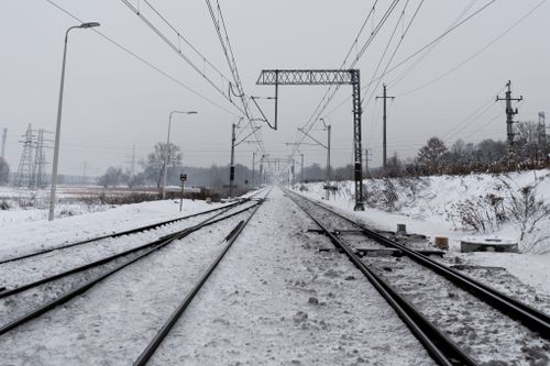 Free Snow-covered railway tracks in rural Kraków, capturing the serene winter landscape. Stock Photo