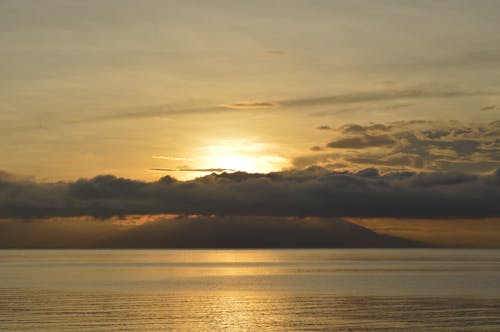 бесплатная Облака над спокойным морем во время заката Стоковое фото