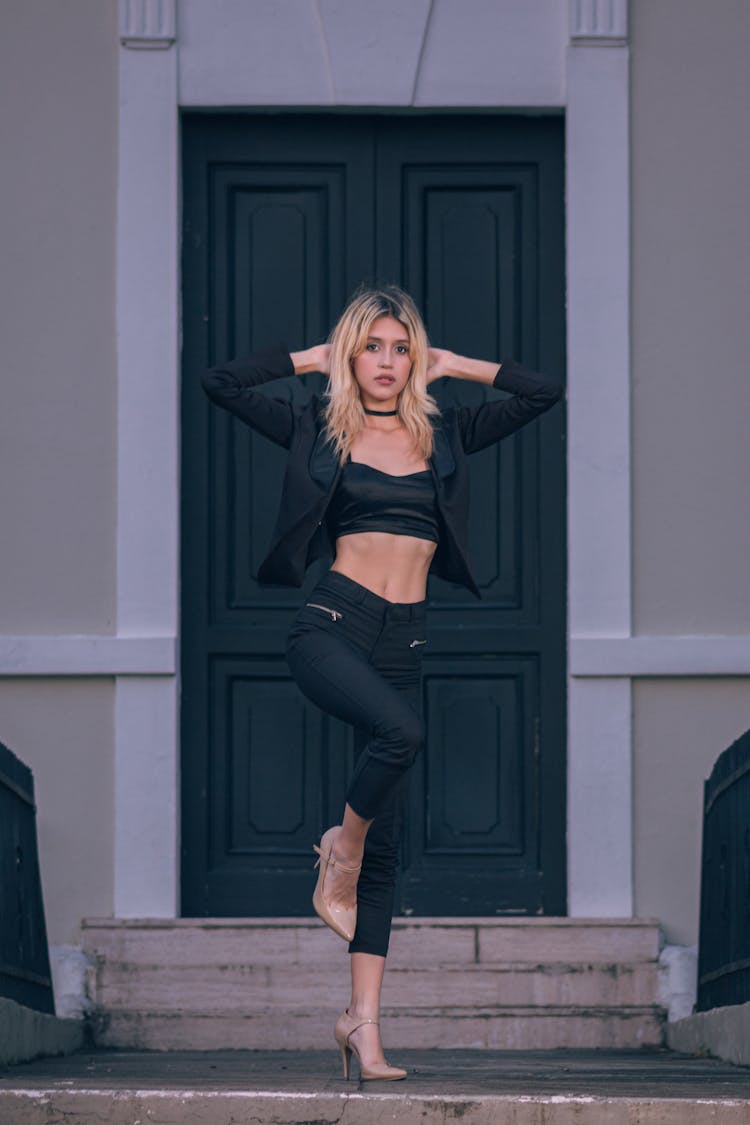 Blonde Woman Posing In Black Outfit In Front Of Green Door 