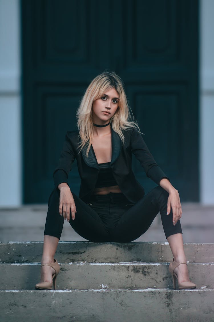 Blonde Woman Posing In Black Outfit In Front Of Green Door 