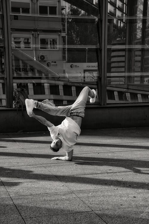 Man in an Acrobatic Dance Pose on the Sidewalk