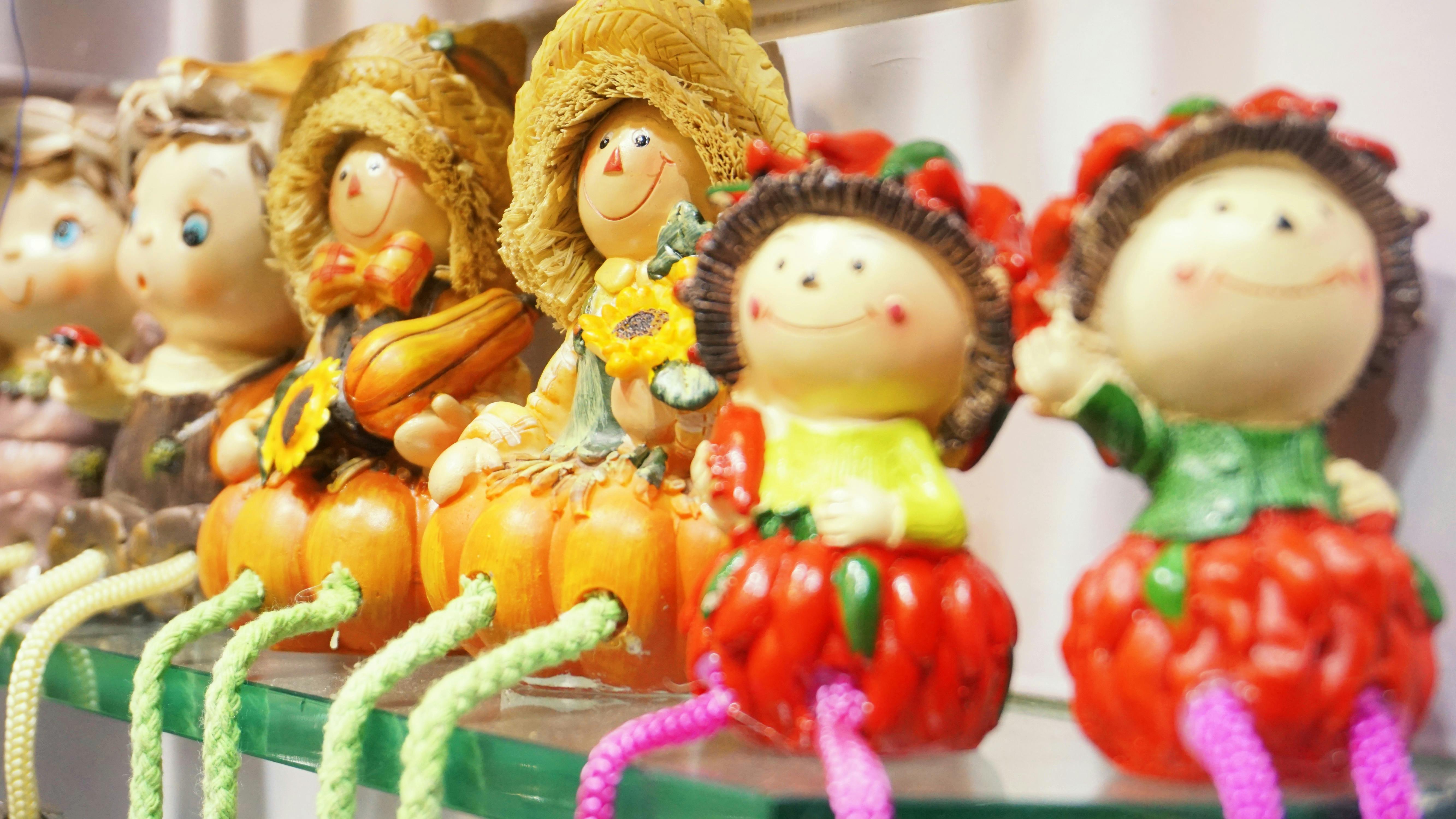 assorted design dolls on glass wall shelf