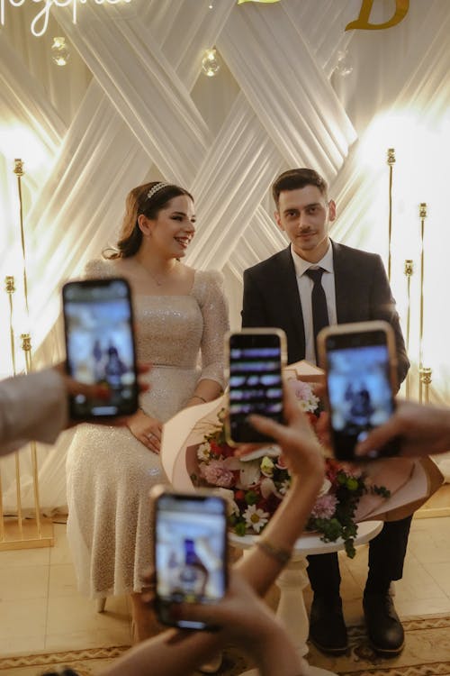 A couple taking pictures of themselves at their wedding