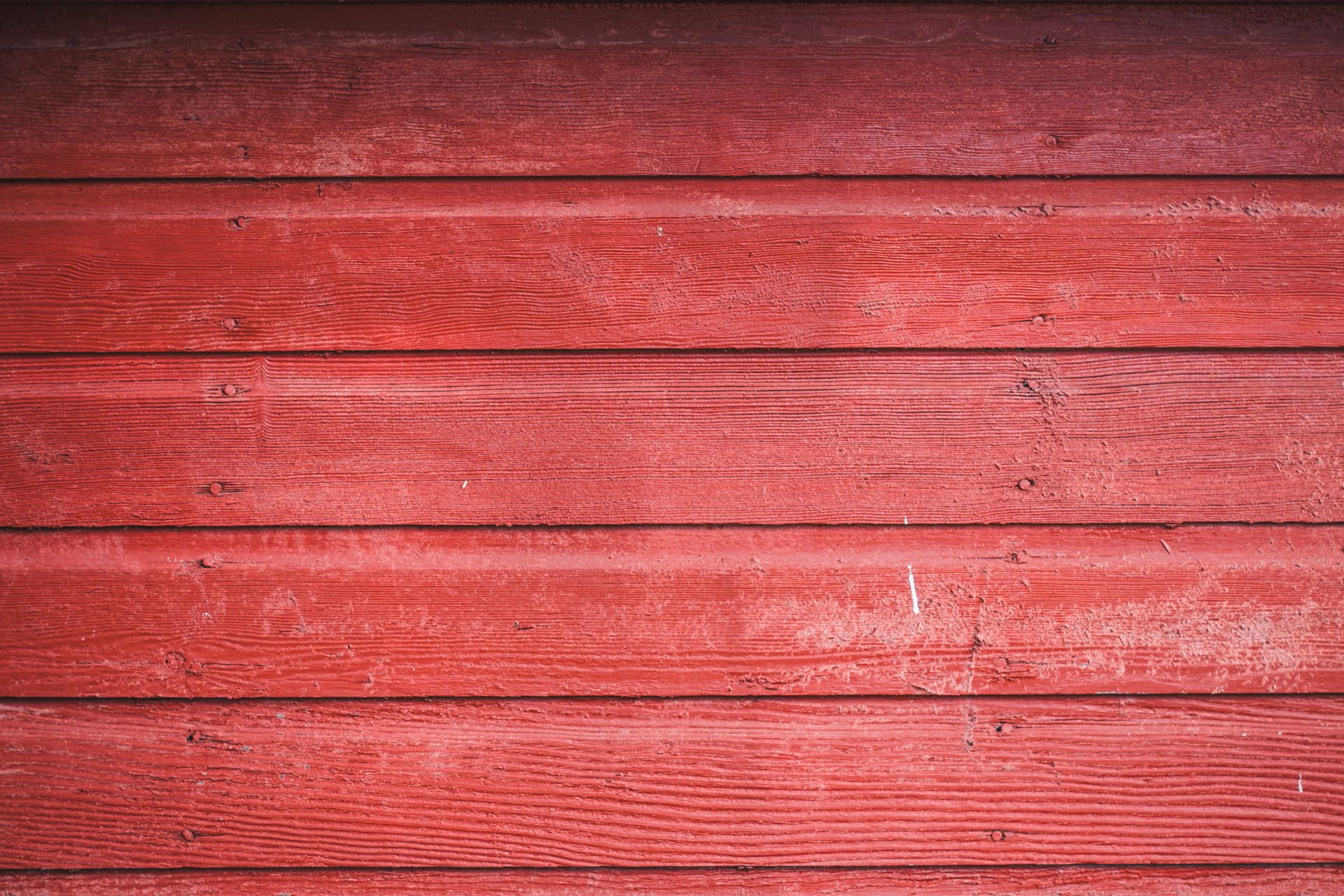 Detailed view of rustic red wooden siding showcasing rich texture and natural grain.