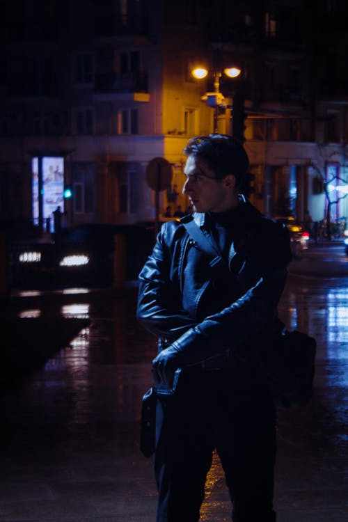 Man in a Leather Jacket Standing on the Street at Night 