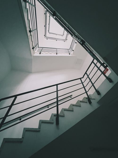 Free Architectural low-angle shot of a modern spiral staircase with metal railings. Stock Photo