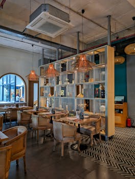 A stylish and cozy restaurant interior in New Delhi featuring wooden chairs and ambient lighting.