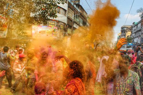 Free Dynamic Holi celebration on Kolkata streets, capturing cultural joy and colorful festivities. Stock Photo