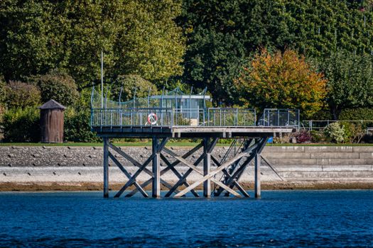 A picturesque pier at Lake Constance in Konstanz, Germany surrounded by lush greenery.