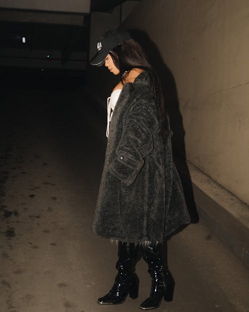 Woman in Black Coat Standing near Wall