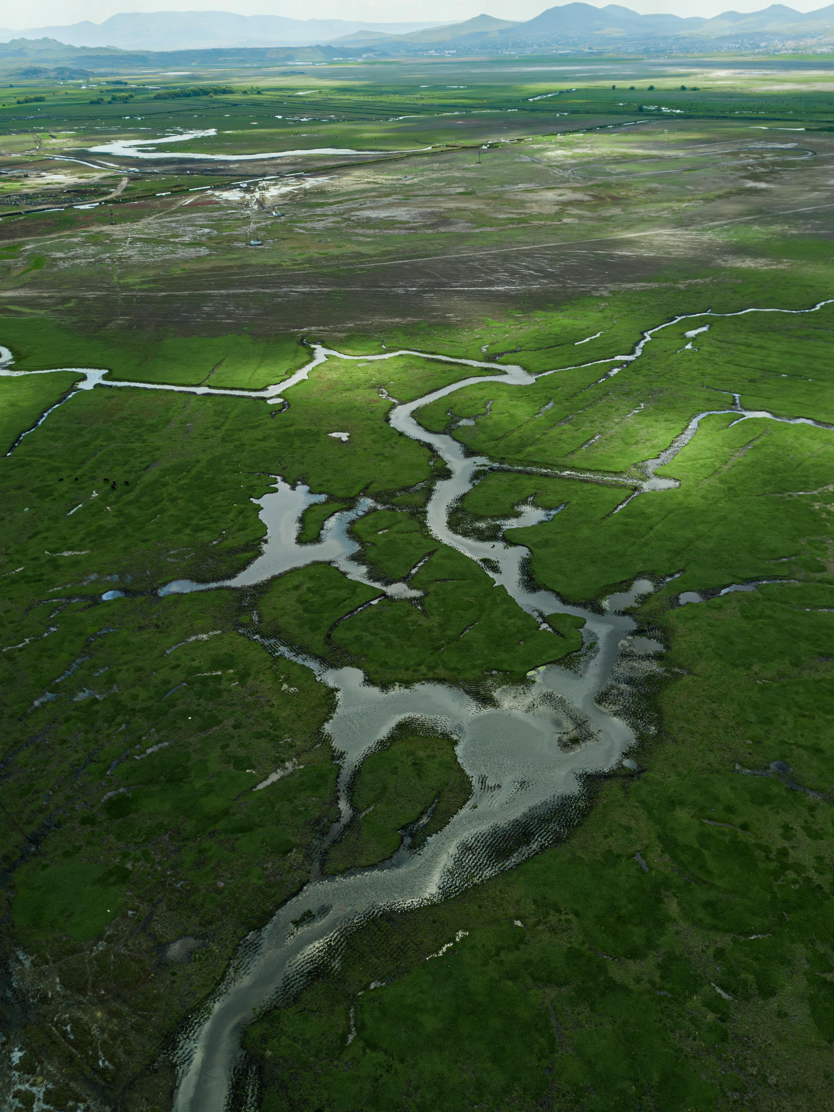 Aerial photograph capturing lush green terrains and a winding river in Kayseri, Türkiye.