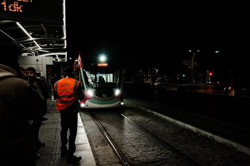Men at the Stop Waiting for the Tram at Night