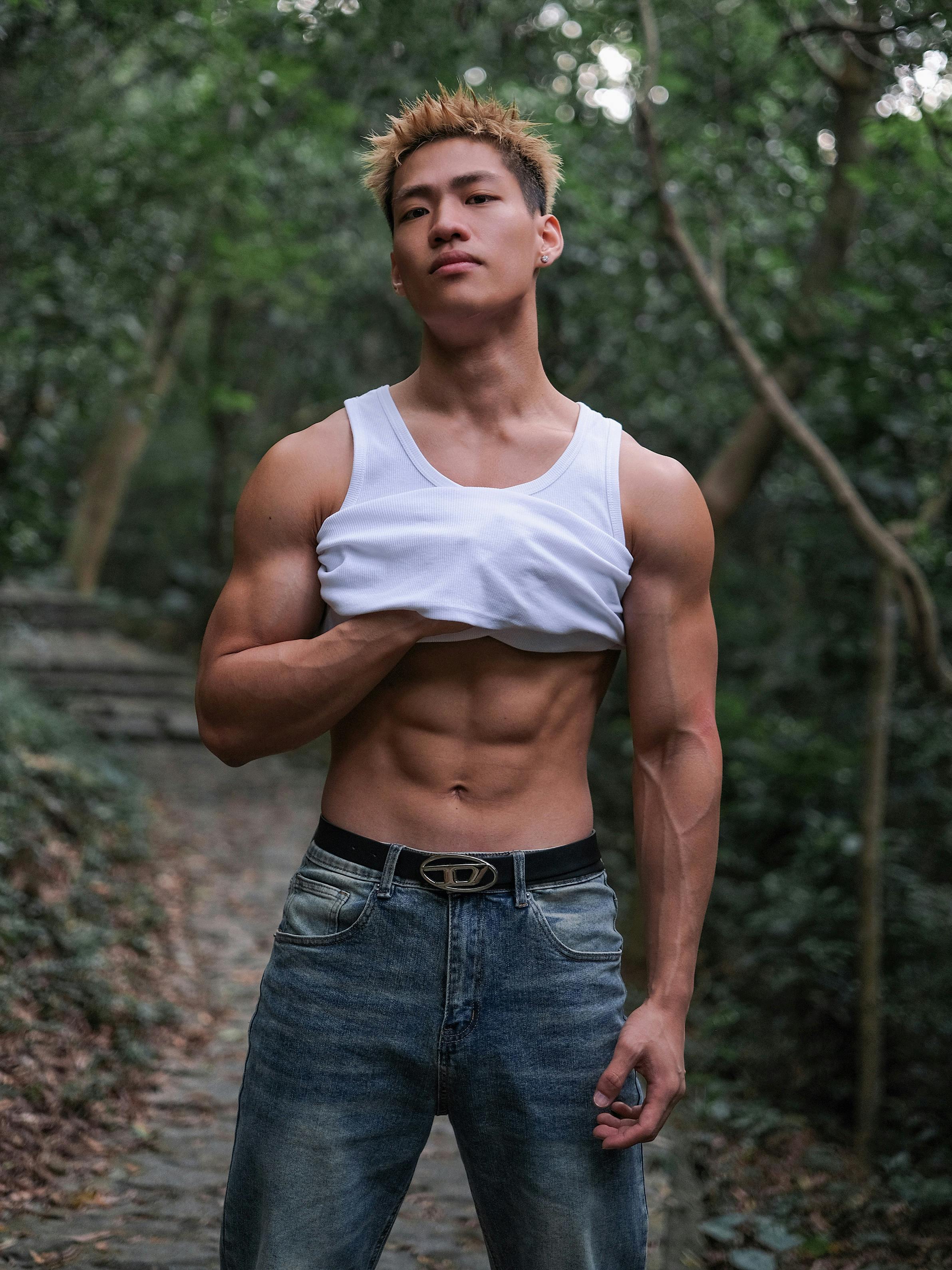 Young Muscular Man Posing Outside in a Tank Top and Jeans · Free