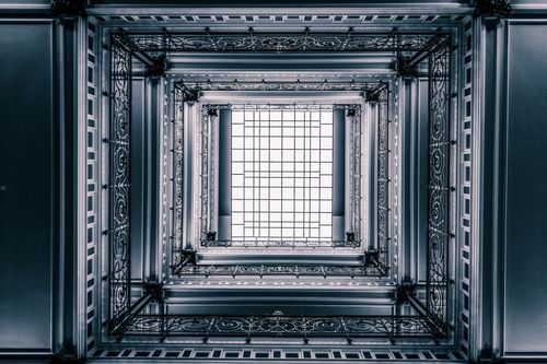 Free Artistic view of a grand architectural interior with intricate metal railings and a glass ceiling in Hamburg. Stock Photo