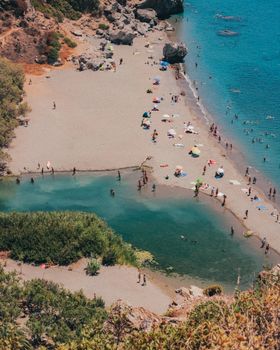 A stunning aerial shot of Preveli Beach showcasing its unique coastal landscape and leisure activities.