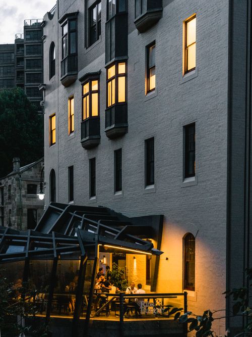 Free Cozy evening scene of people dining at a modern urban apartment terrace. Stock Photo
