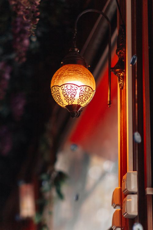 Free A vintage decorative wall lantern casting warm light in an indoor setting. Stock Photo