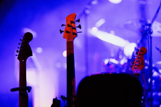 Electric guitars on stage under colorful concert lights, capturing the vibrant music atmosphere.