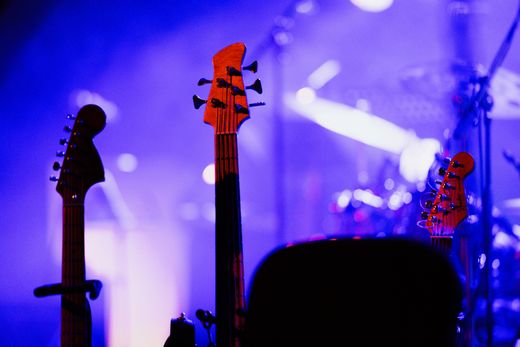 Electric guitars on stage under coloured lights — photo by K on Pexels