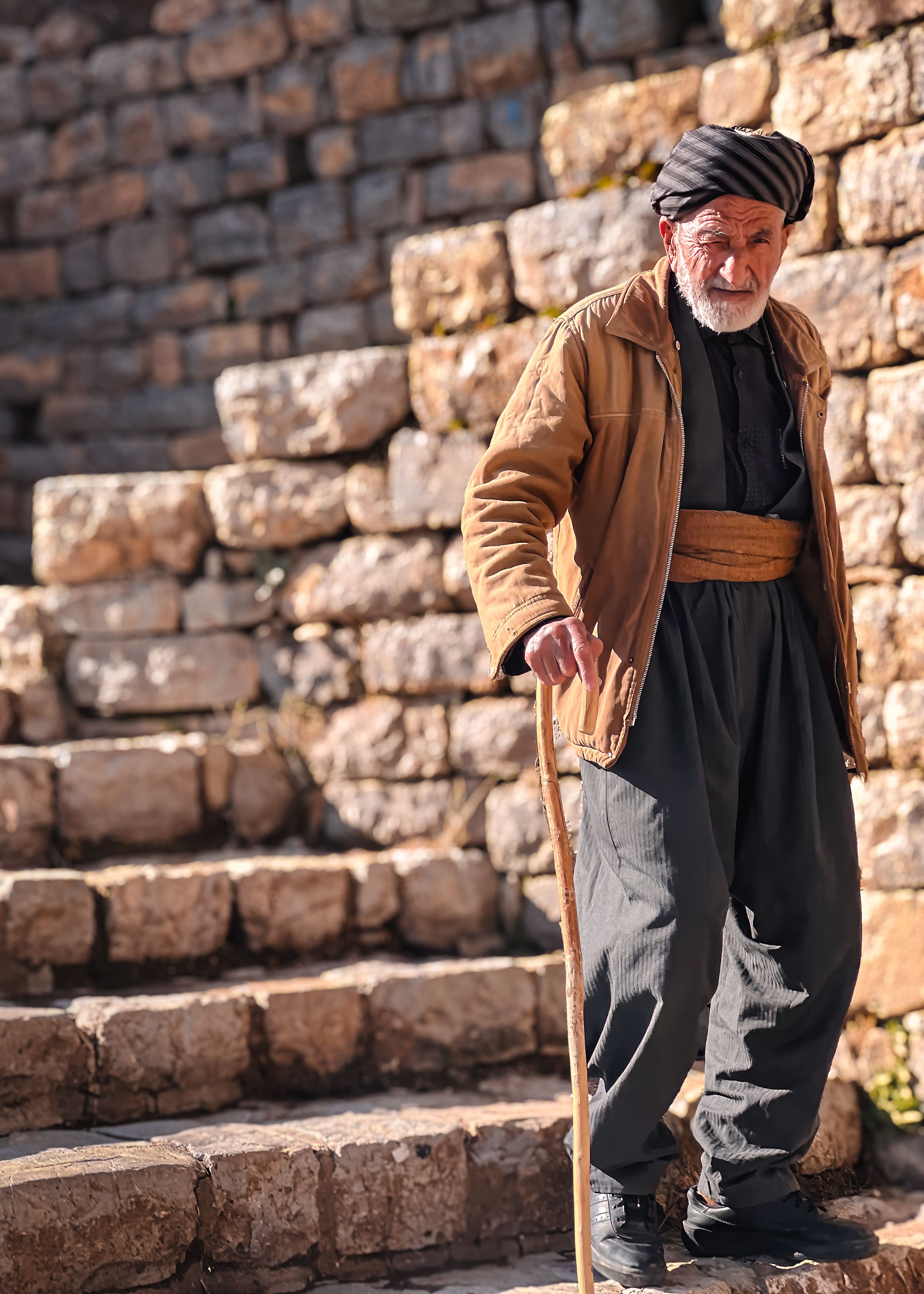 An old man with a cane walking down some steps · Free Stock Photo