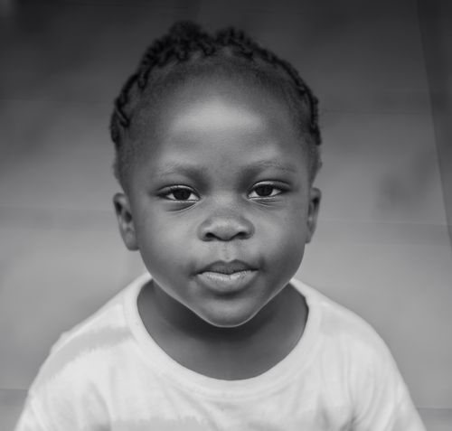 Free A thoughtful portrait of a young child with braided hair in black and white. Stock Photo