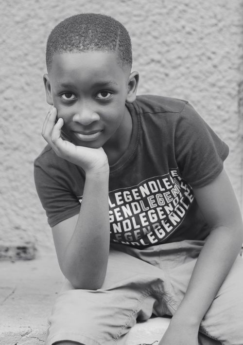 Free A black and white portrait capturing the charm and innocence of a young boy in a thoughtful pose. Stock Photo