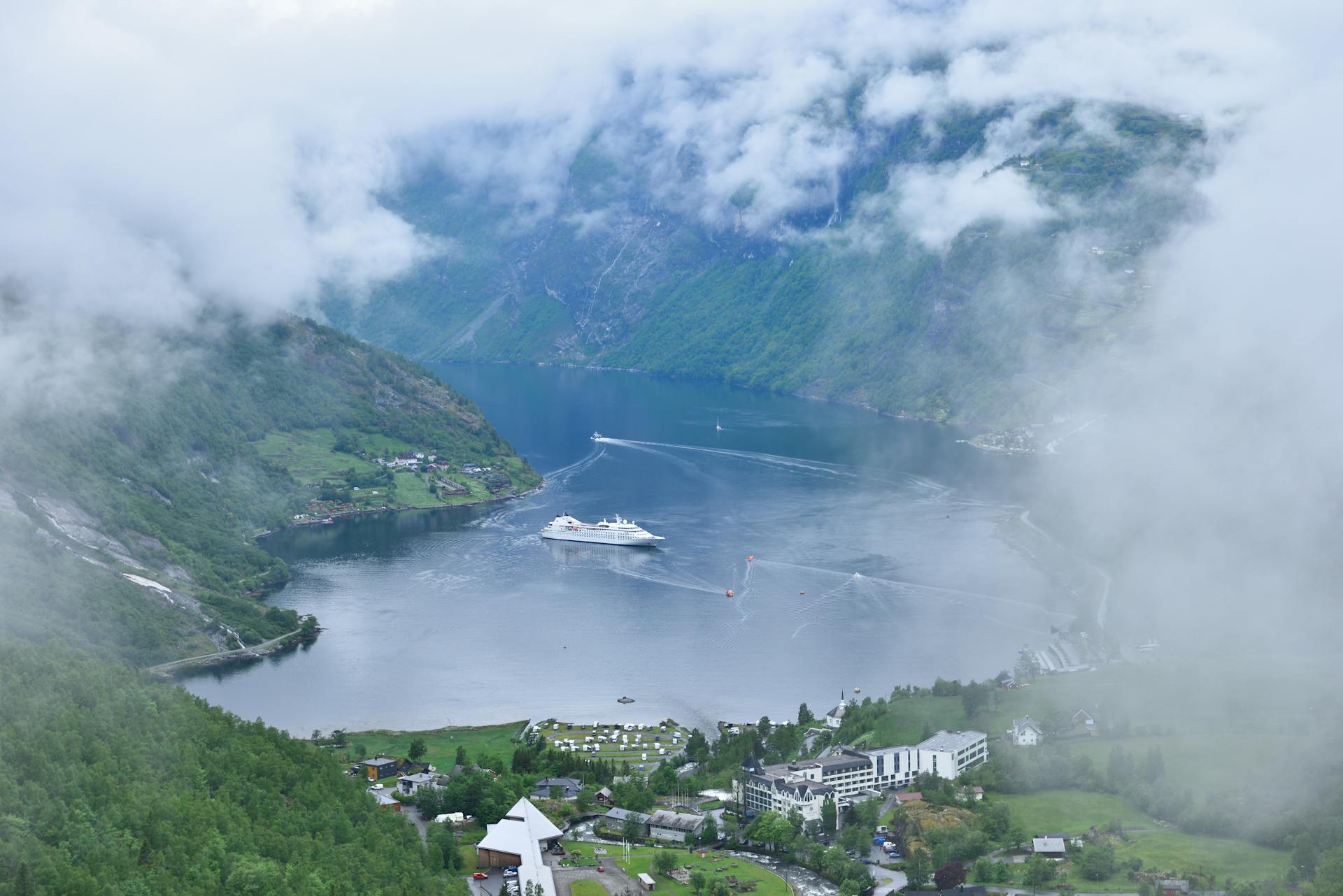 Breathtaking aerial view of Geiranger Fjord in Norway with a cruise ship and lush scenery.