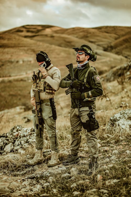 Soldiers in Uniforms Standing on a Hill and Holding Weapons 