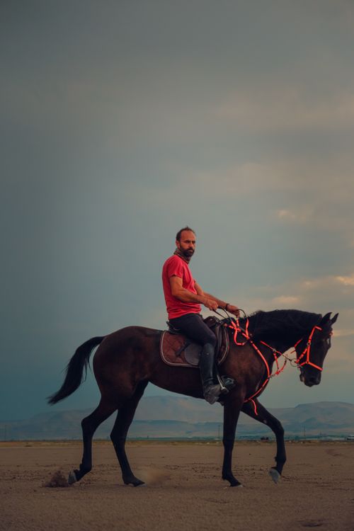 Operate Man Riding Man Riding a Horse on a Field · Free Stock Photo