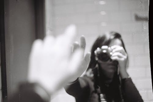 Woman with Camera Taking Pictures in Mirror