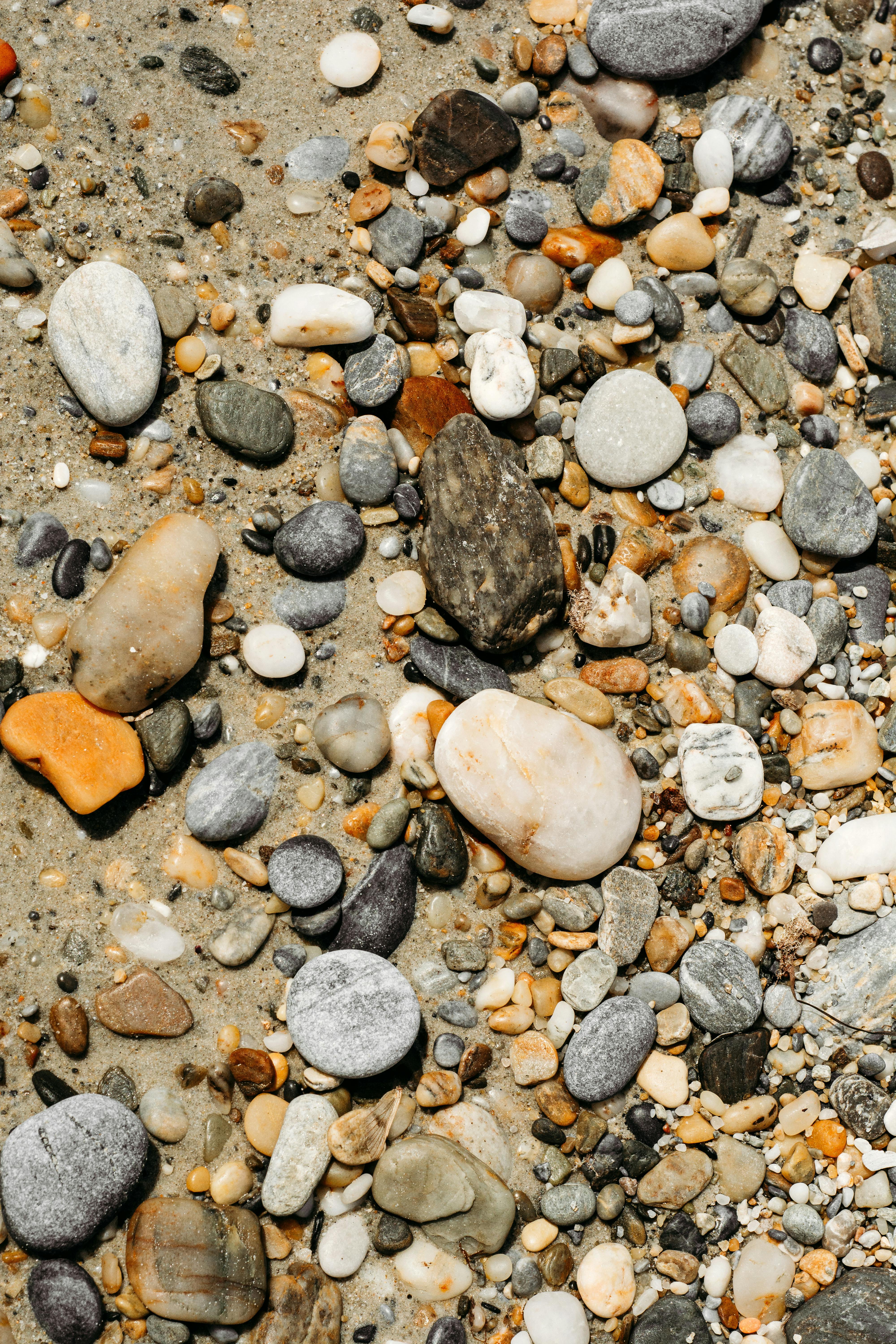 a close up of rocks and pebbles on the beach