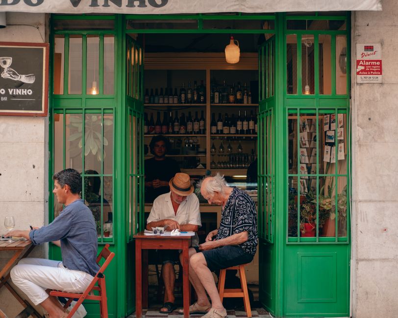 Elderly men enjoying drinks at a cozy Lisbon wine bar. Perfect street ambience. — Bica, Portugal.