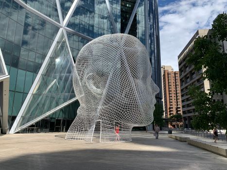 Modern sculpture in downtown Calgary, set against the backdrop of urban architecture.