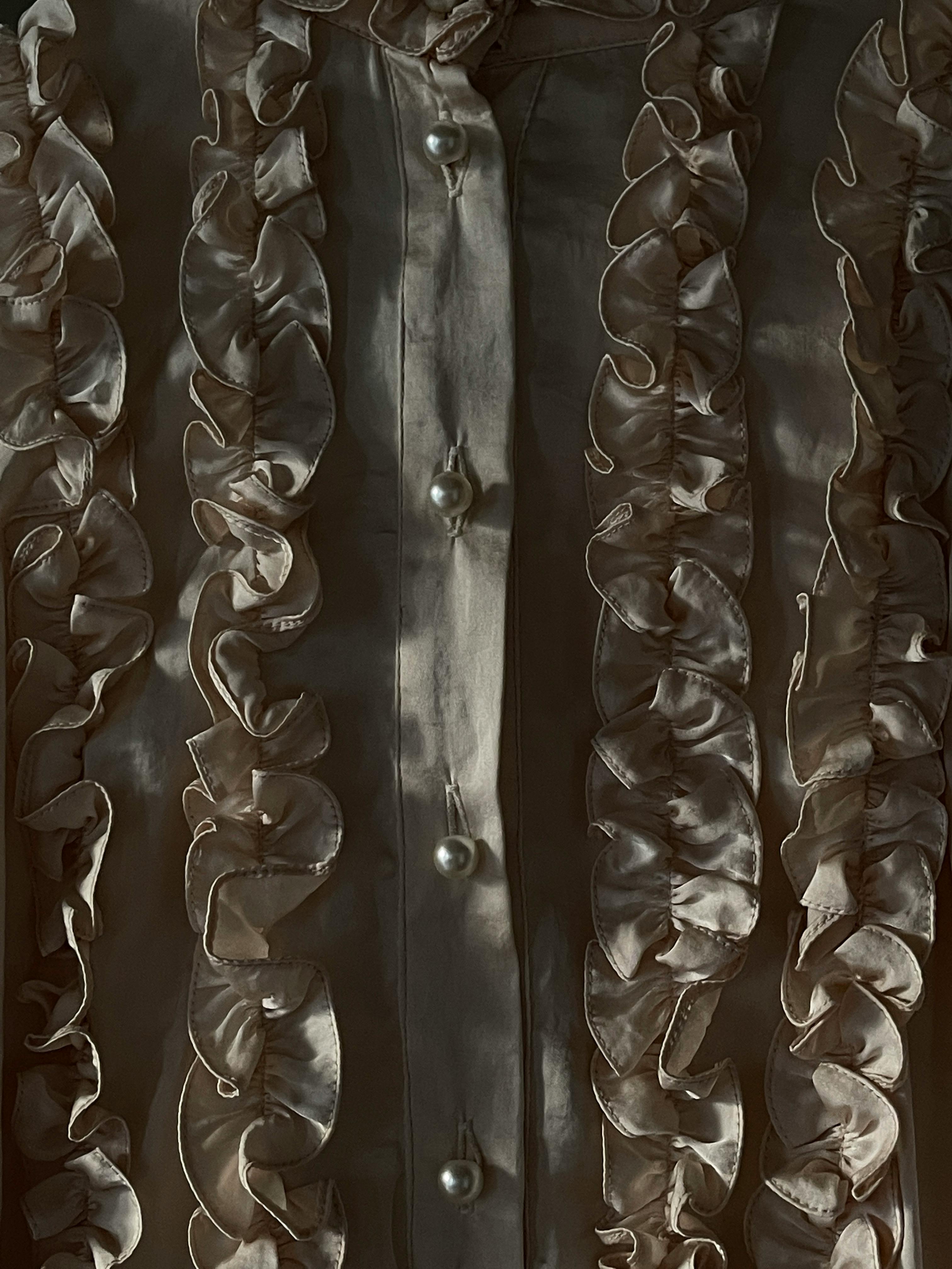 Close-up of an antique ruffled shirt with luxurious pearl buttons.