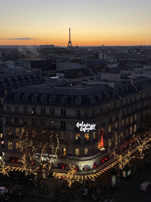 Aerial View of an Illuminated Building and the Eiffel Tower in the Background at Sunset, Paris, France