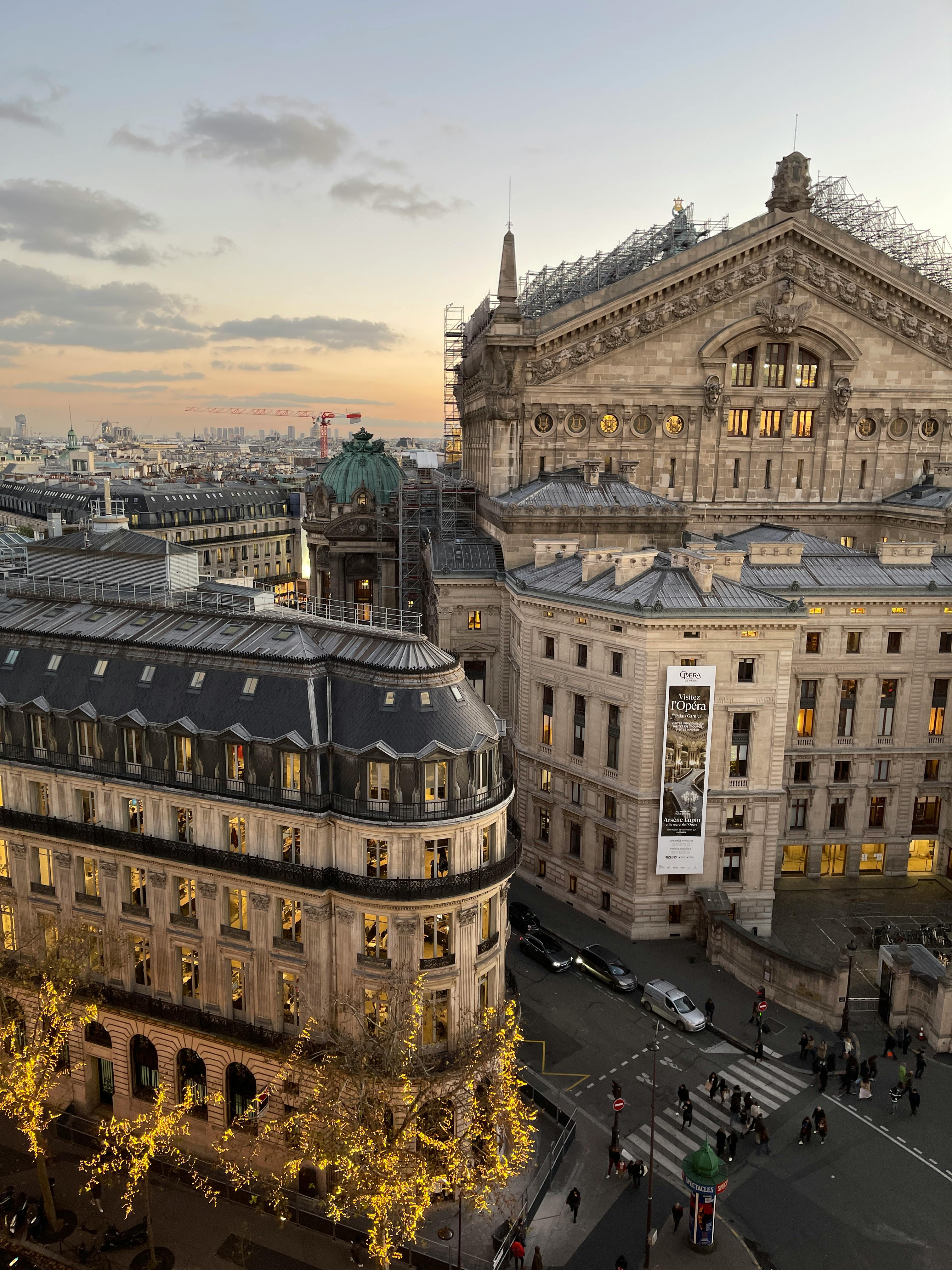 Scenic aerial view of Palais Garnier in Paris at sunset, highlighting iconic architecture.