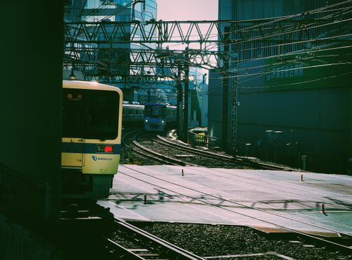 Free Passenger trains traverse a bustling urban railway in downtown Tokyo. Stock Photo