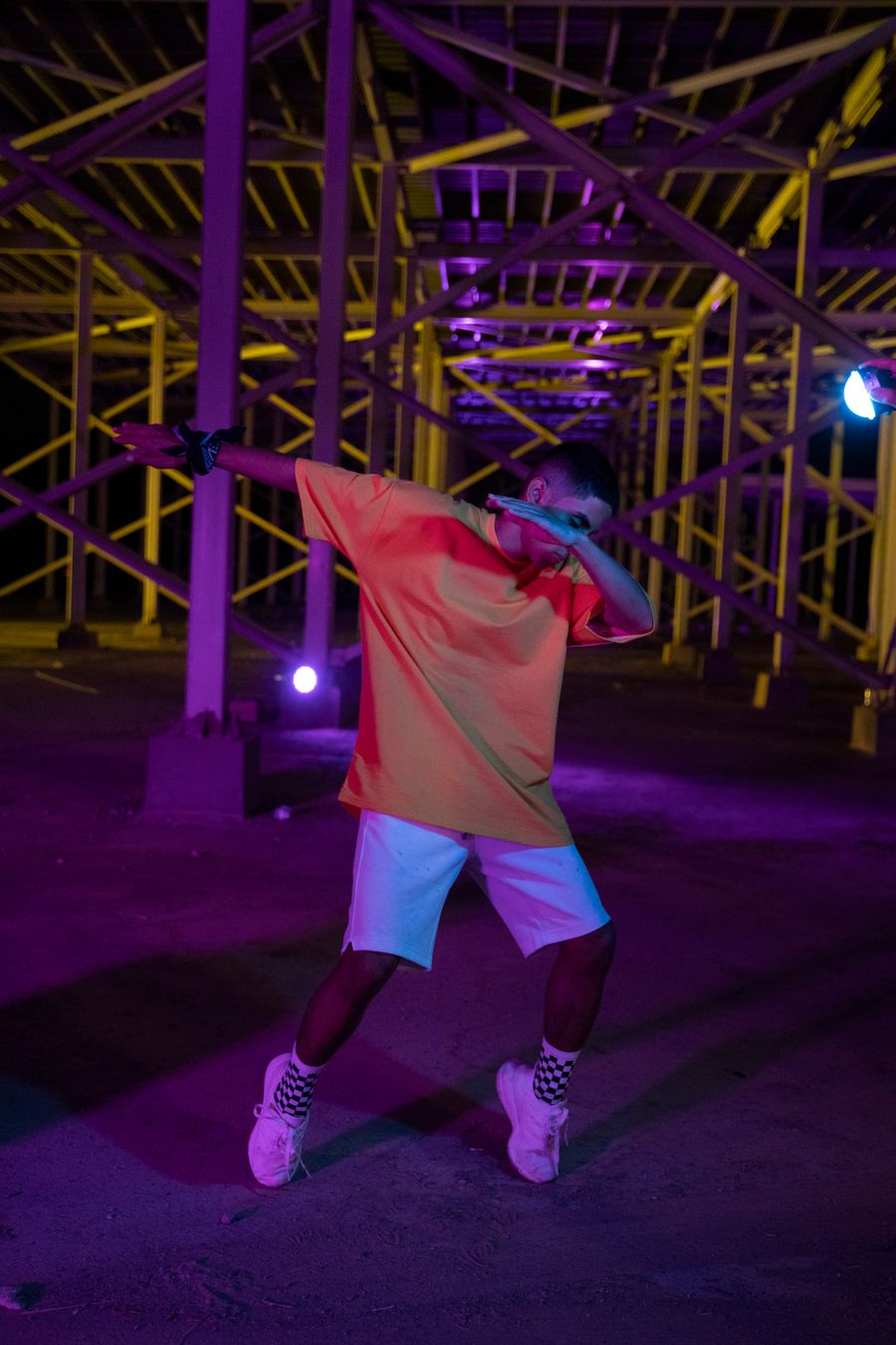 Hip-hop dancer mid-move under red neon club lights