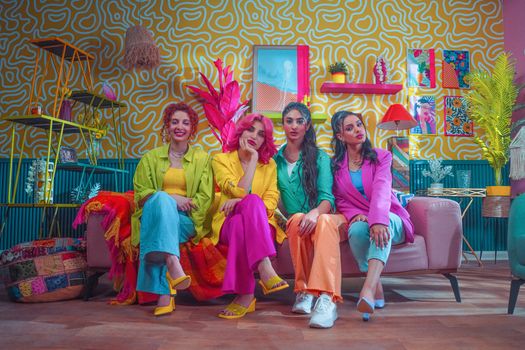 Vibrant portrait of four women in trendy outfits in a colorful indoor setting.
