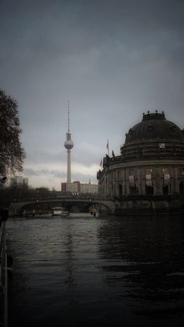 Scenic view of Berlin's skyline with the Fernsehturm and Bode Museum reflecting in the river.