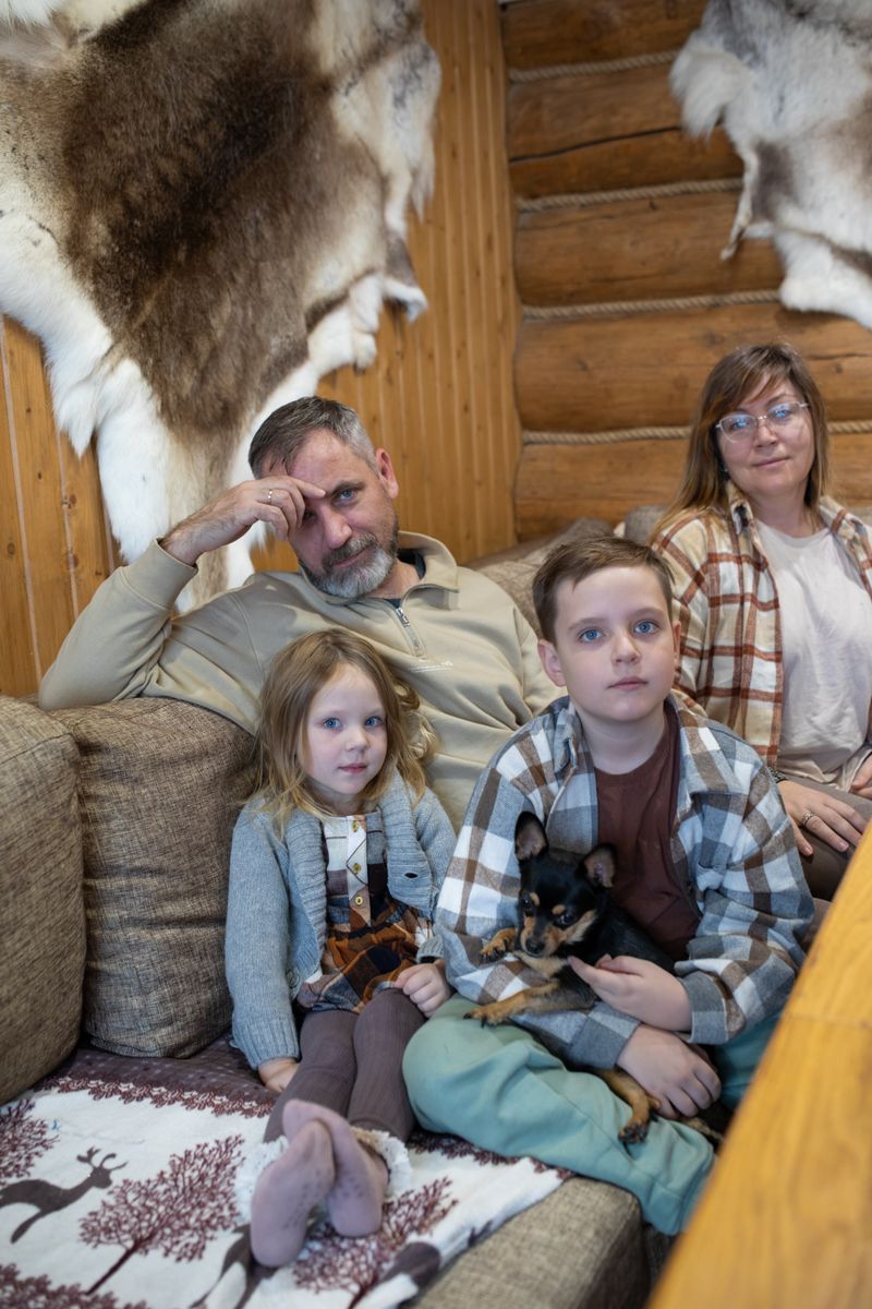 A family sitting together on a couch in a cozy cabin