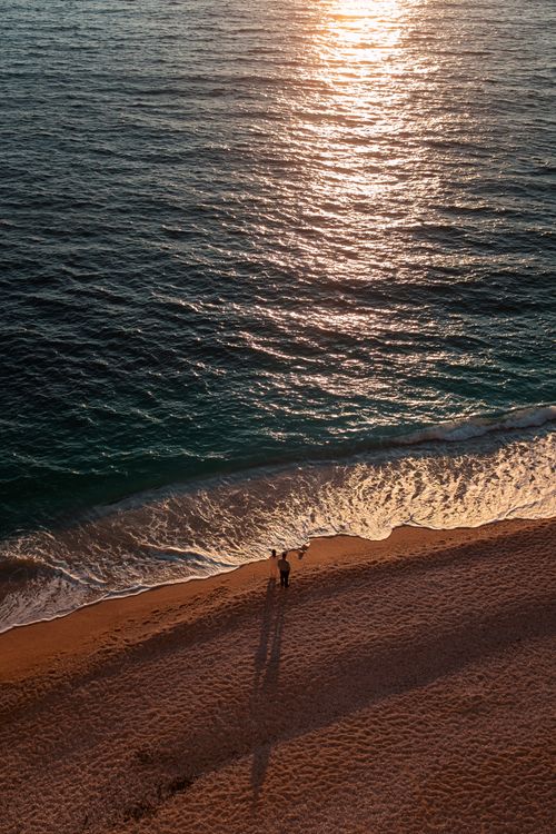 Free Couple enjoying a sunset walk on Kaputaş Beach in Türkiye with scenic sea views. Stock Photo