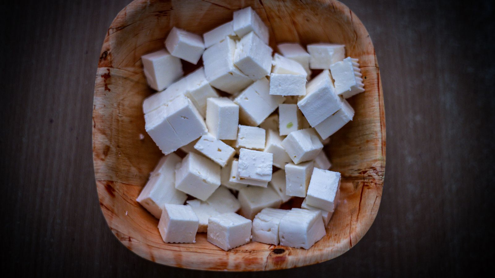 Fresh feta cheese cubes in a rustic wooden bowl — photo by Patrick on Pexels Fresh feta cheese cubes in a rustic wooden bowl