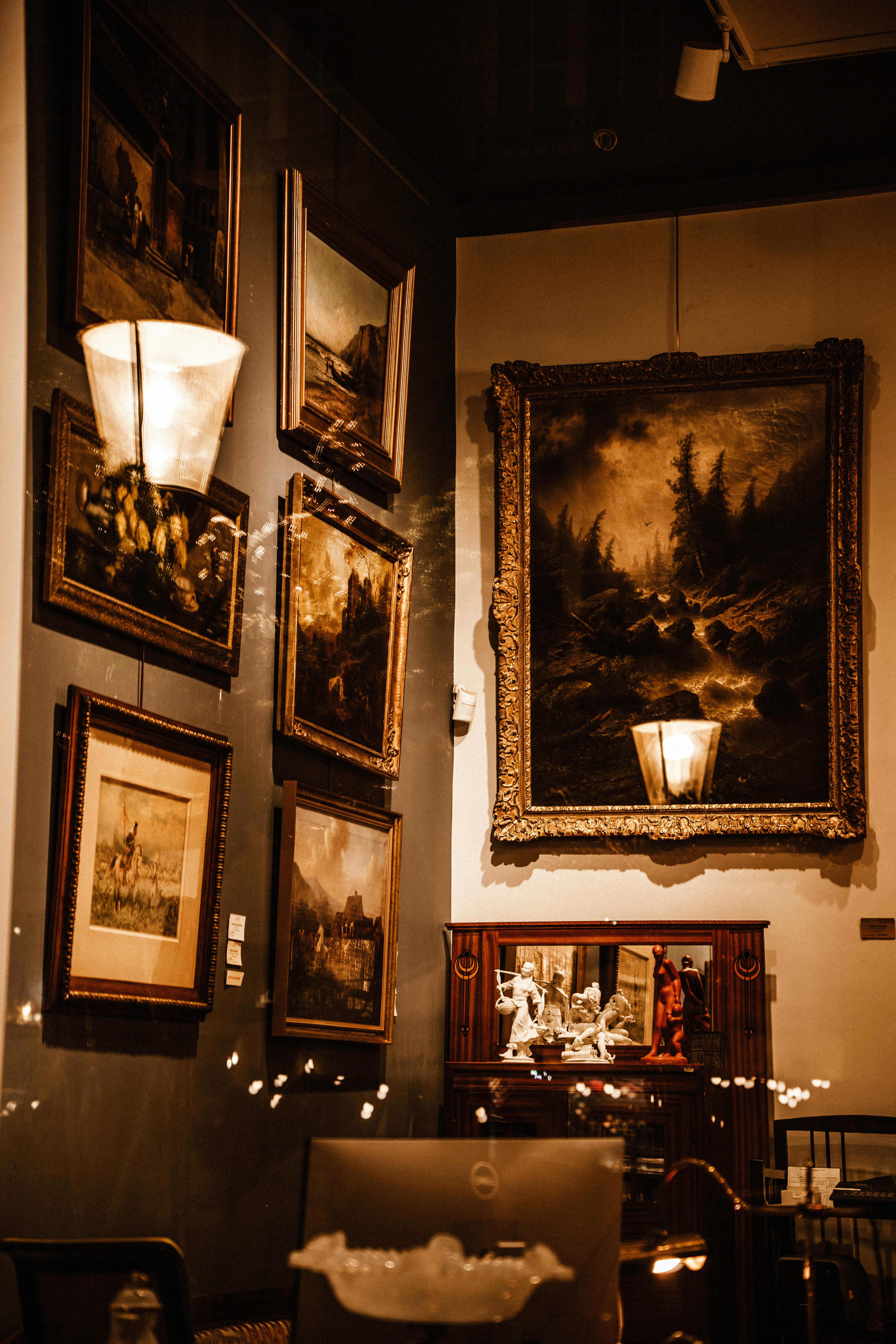 A cozy gallery corner showcasing luxury paintings and sculptures in warm lighting.