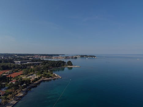 Stunning aerial view of Poreč, Croatia, showcasing the coastline and blue sea under a clear sky.