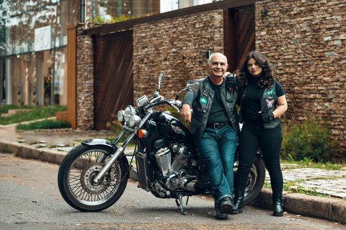 Free Father and daughter pose with motorcycle in urban setting. Casual style and street vibe. Stock Photo