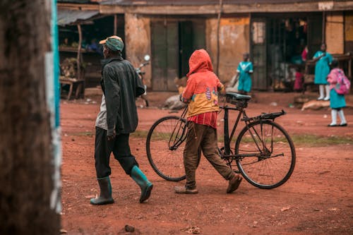 Men Walking with Bicycle in Village