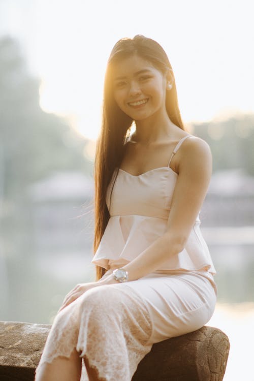 Smiling Woman Sitting in White Clothes